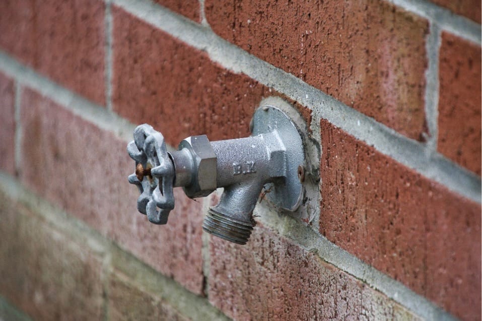 Hose bib on the side of a commercial building; property maintenance 
