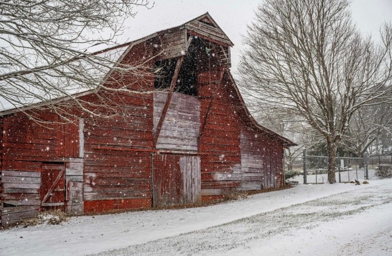 old barn with missing front window and structurally unsound.