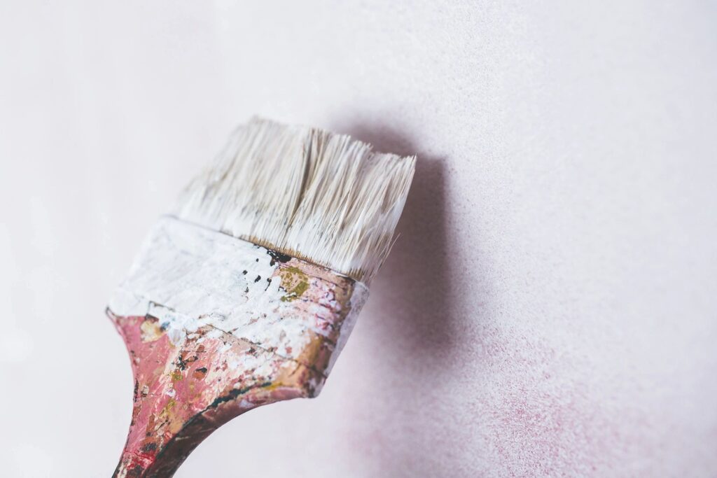 paint on a paintbrush starting to prime the walls
